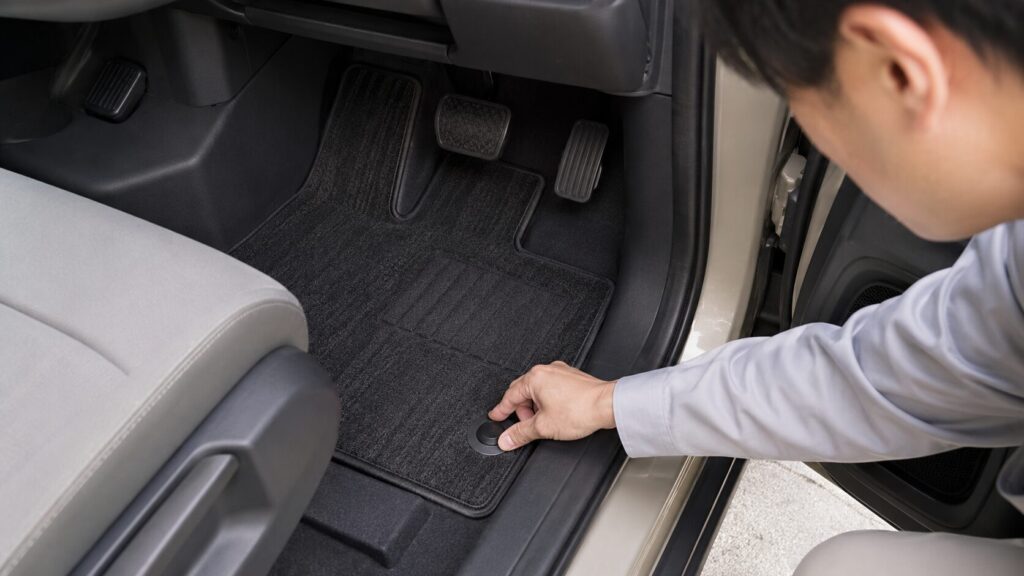 新型フリードの運転席フロアマットを固定フックで確認しズレ対策をする様子